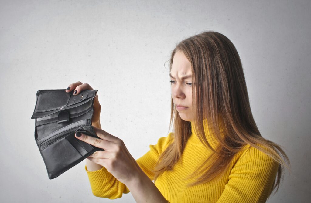 woman looking in empty wallet