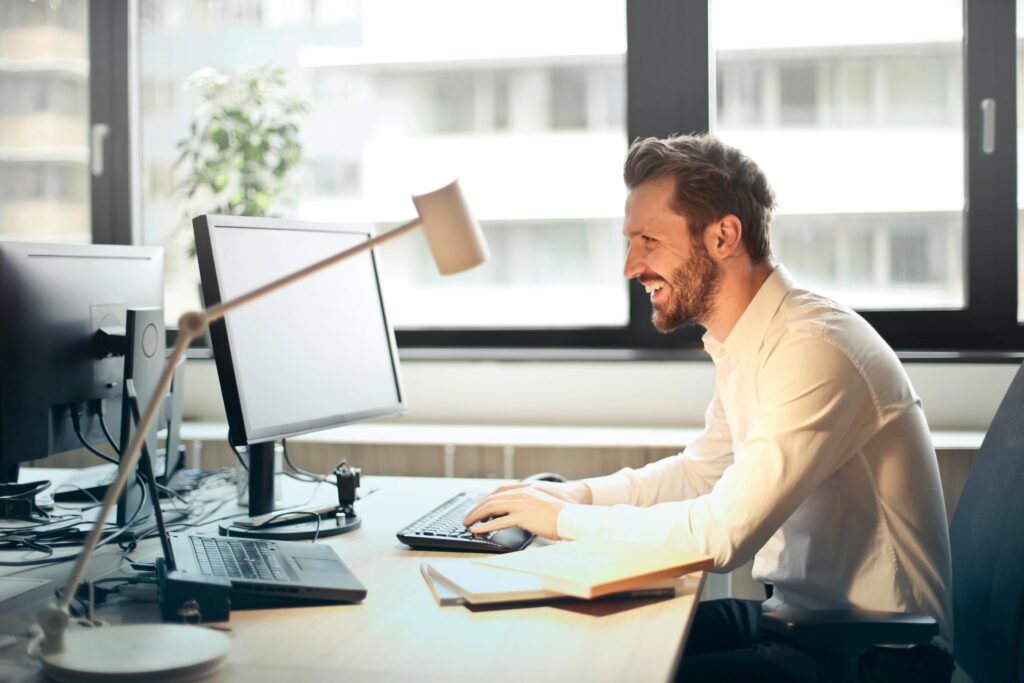 man sat at desk reading emails