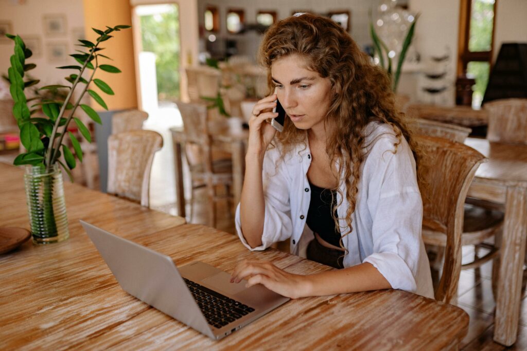 Woman at dining room table with laptop.